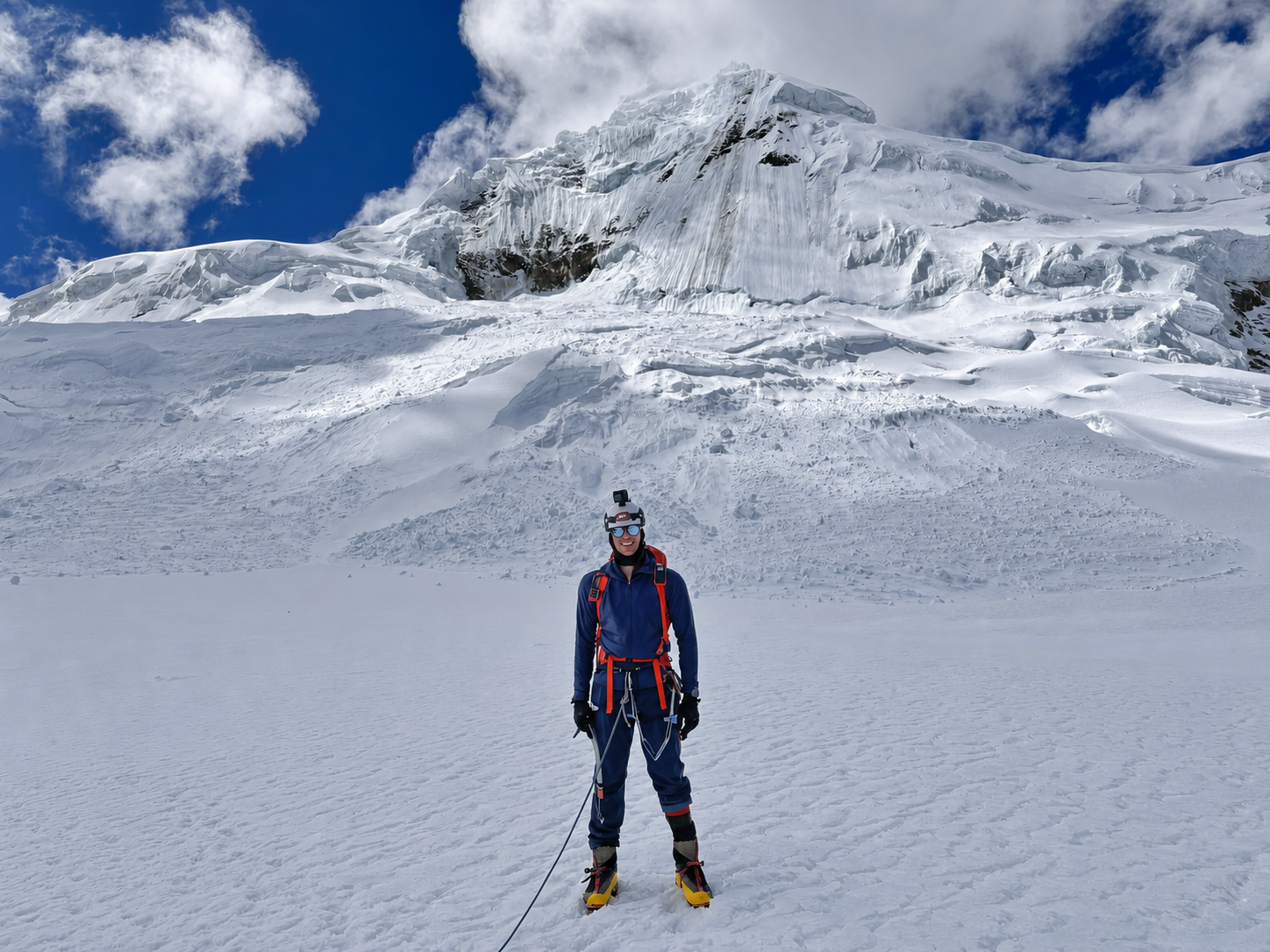 Max Patwardhan standing on a glacier beneath a snowy summit